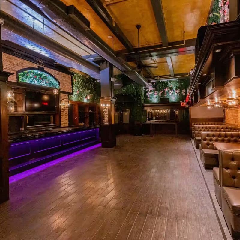 Interior of The Dean NYC with neon lighting and greenery-covered walls in the Garment District